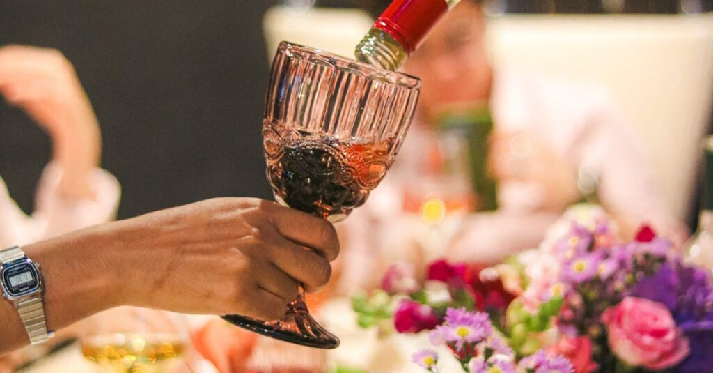 A vibrant dinner scene with wine pouring and floral arrangements.