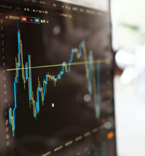 Detailed view of financial trading graphs on a monitor, illustrating stock market trends.