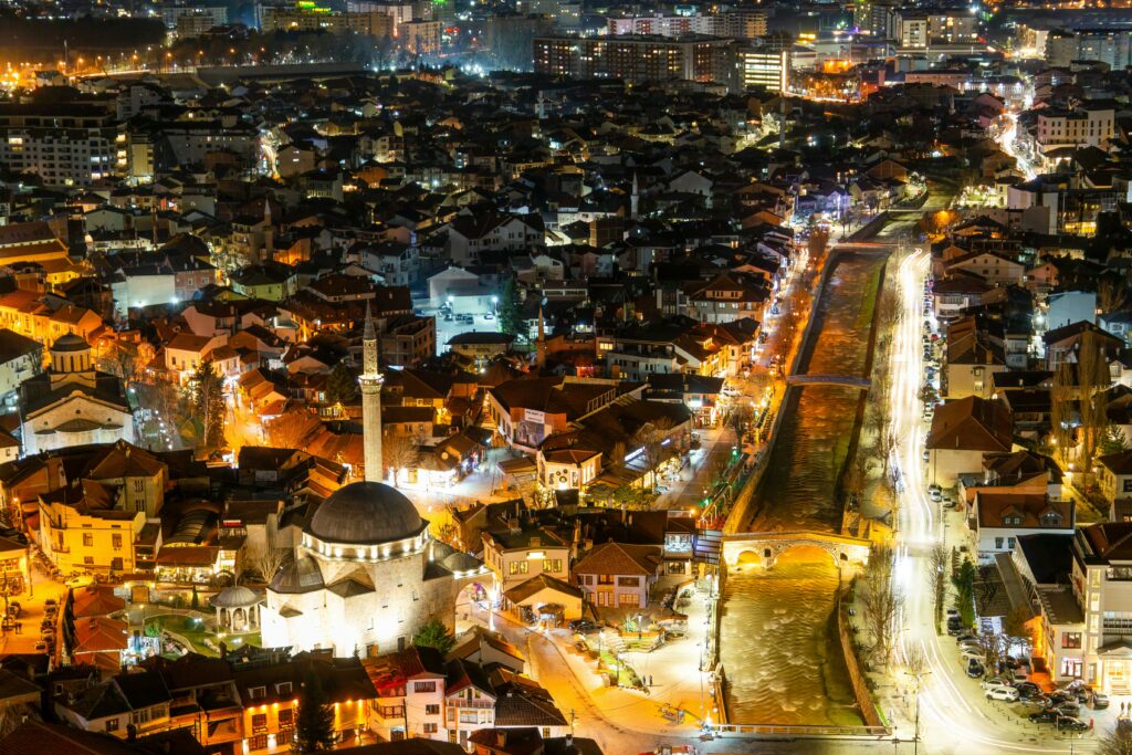 Captivating aerial view of Prizren at night showcasing illuminated streets and architecture.