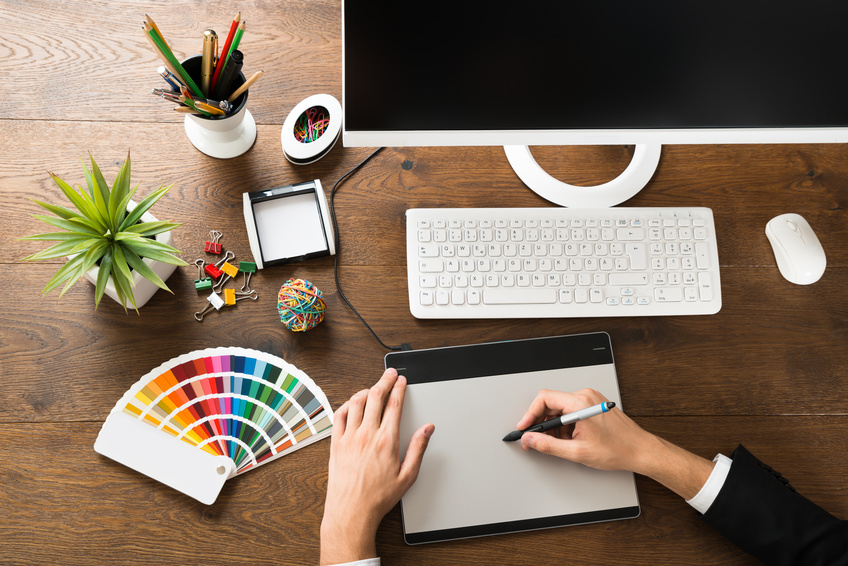 Young Male Designer Using Digital Graphic Tablet With Stylus At Desk